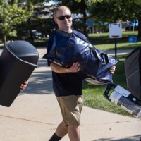 3 GVSU Alumni with their hands full as they unload a car and carrying a new laker's belongings into dorm